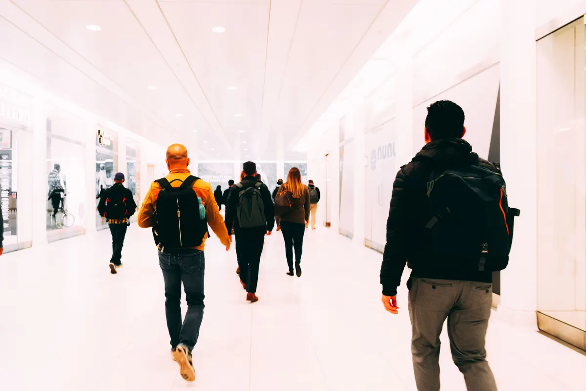 Travellers moving through an airport terminal with carry on bags