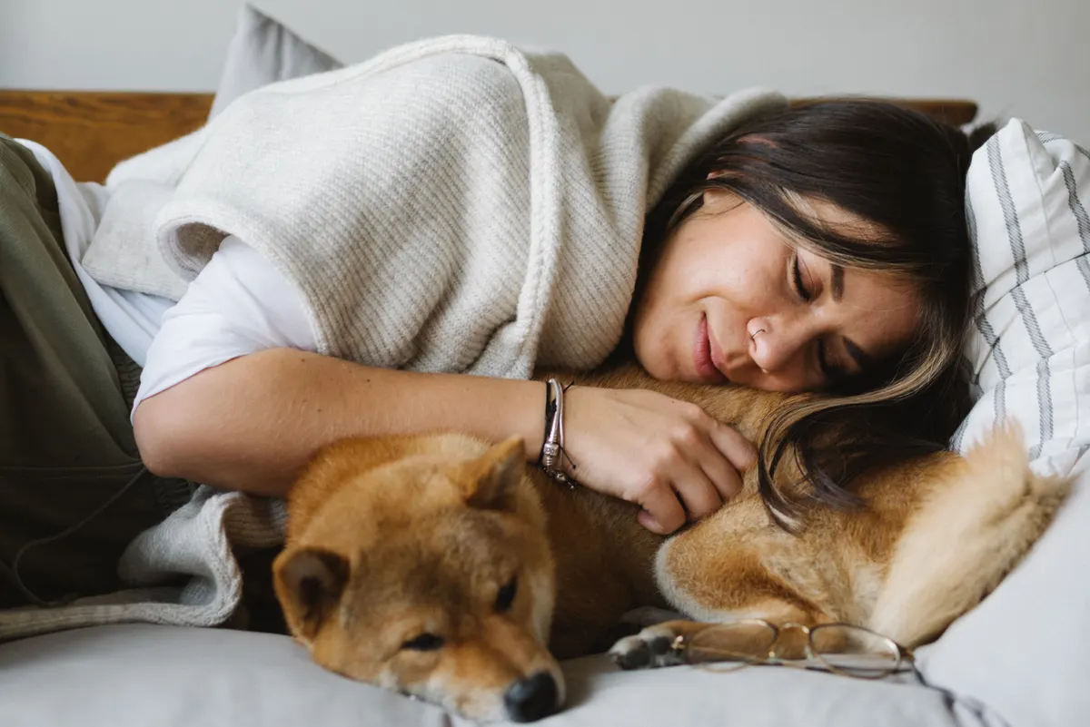 Dog and owner napping together, the point of a human dog bed